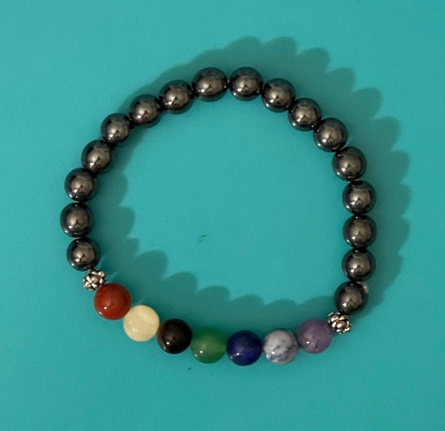 Elevate your jewelry collection with the charm of the Chakra Bracelet featuring Hematite Beads, a fashionable and spiritually meaningful choice at KJsKrystals, LLC.