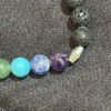 Adorn your wrist with the captivating Chakra Bracelet featuring Lava Beads and Barrel Spacers, available at KJsKrystals, LLC, and experience the harmonious blend of energy and style it brings.