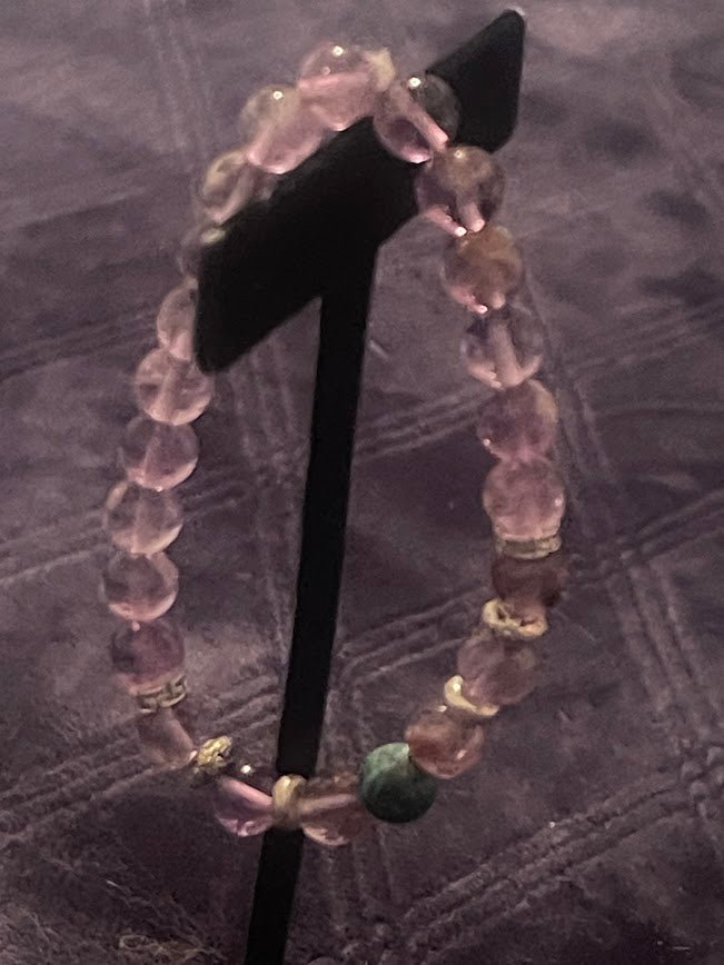 Discover the captivating beauty of the Amethyst Bracelet with one Malachite Bead from KJsKrystals, LLC, and experience the unique charm and balance it brings.