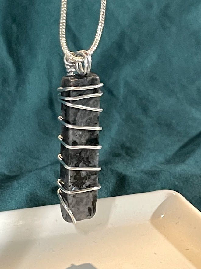 Adorn your neck with the captivating Larvikite Pendant, available at KJsKrystals, LLC, and experience the calming energy and elegant design it brings to your jewelry collection.